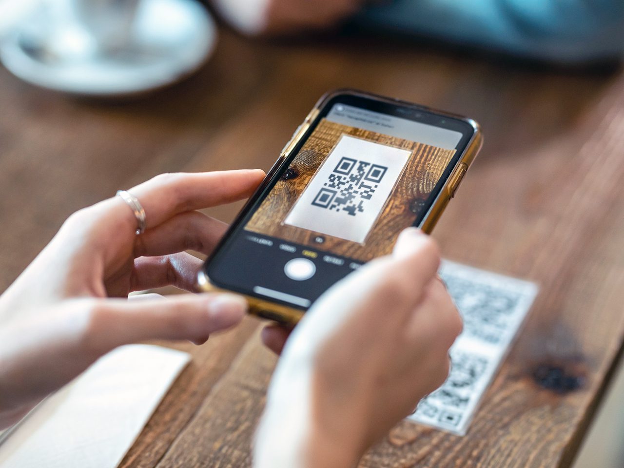 Vibrant street vendor in Buenos Aires market holding phone displaying QR code for USDT stablecoin payment, eager customers scanning with their smartphones